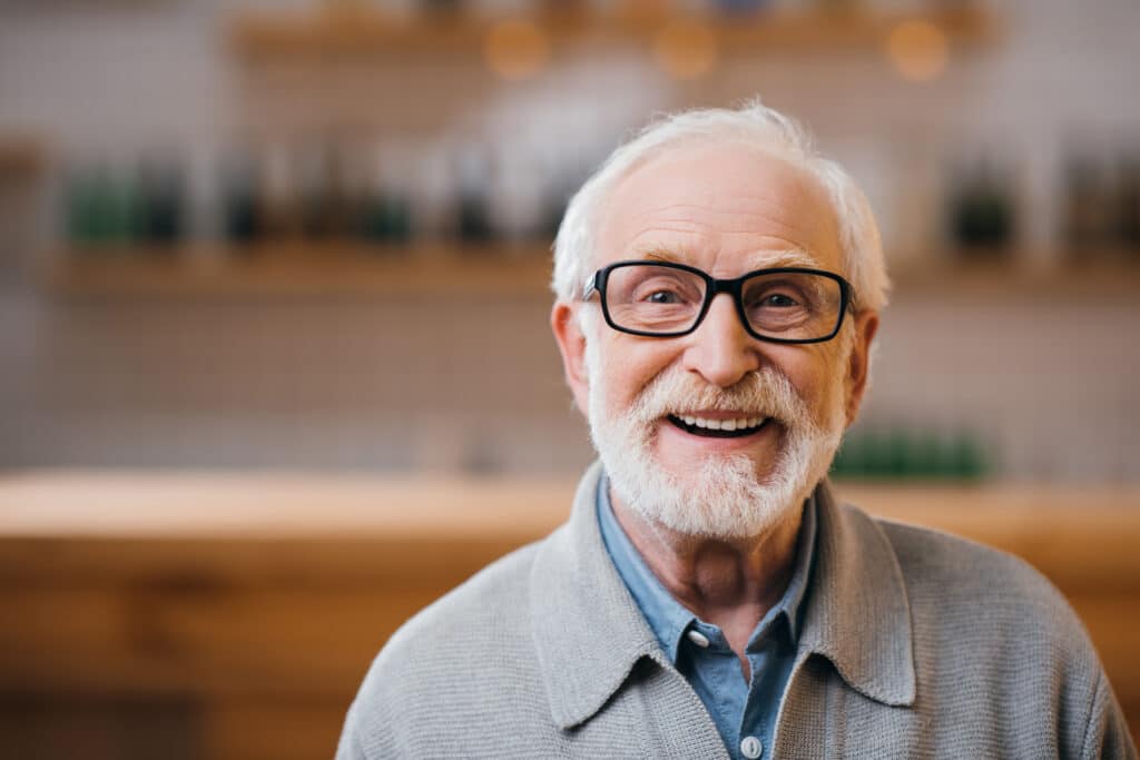 Close-up,Portrait,Of,Happy,Senior,Man,Looking,At,Camera